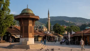 น้ำพุ Sebilj ในย่าน Baščaršija เมืองซาราเยโว โดยมีมัสยิดและภูเขา Trebević เป็นฉากหลัง