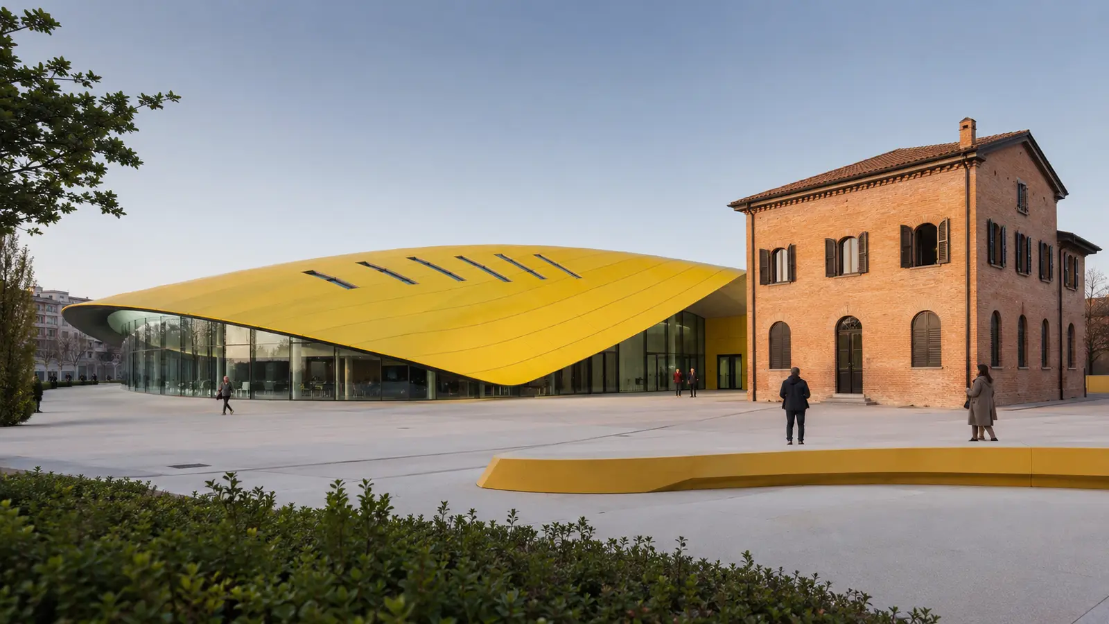 อาคารหลังคาสีเหลืองของ Museo Enzo Ferrari ข้างบ้านอิฐประวัติศาสตร์ในเมืองโมเดนา