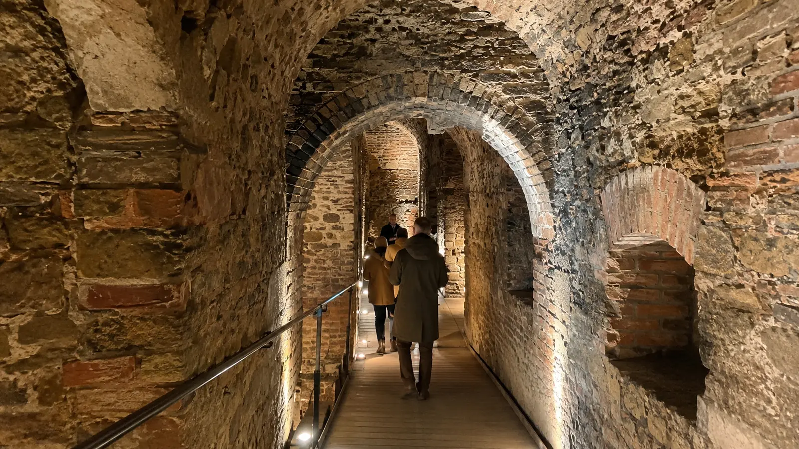 ทางเดินหินและอิฐภายใน Pilsen Historical Underground พร้อมกลุ่มผู้เข้าชม