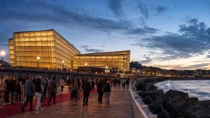 ผู้ชมเทศกาลภาพยนตร์เดินเข้าสู่ศูนย์ประชุม Kursaal ริมหาด Zurriola ในซานเซบาสเตียนช่วงพลบค่ำ