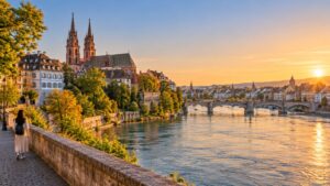 วิวบาเซิลริมแม่น้ำไรน์ มหาวิหาร Basel Münster และสะพาน Mittlere Brücke ยามเย็น